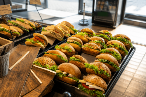 Frisch belegte Brötchen mit Salat, Käse und Aufschnitt in der Verkaufstheke bei Kalle-Bäcker
